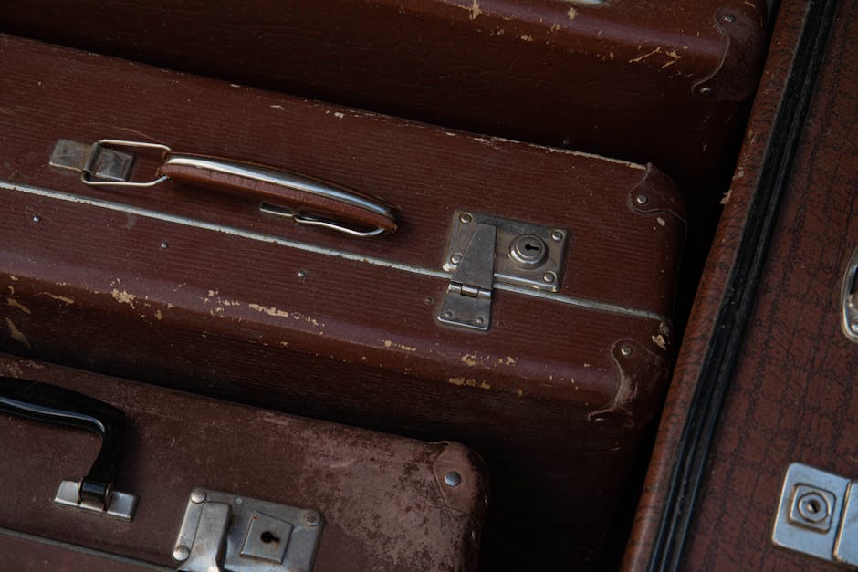 Detailed view of stacked vintage brown suitcases showcasing their classic design and wear.